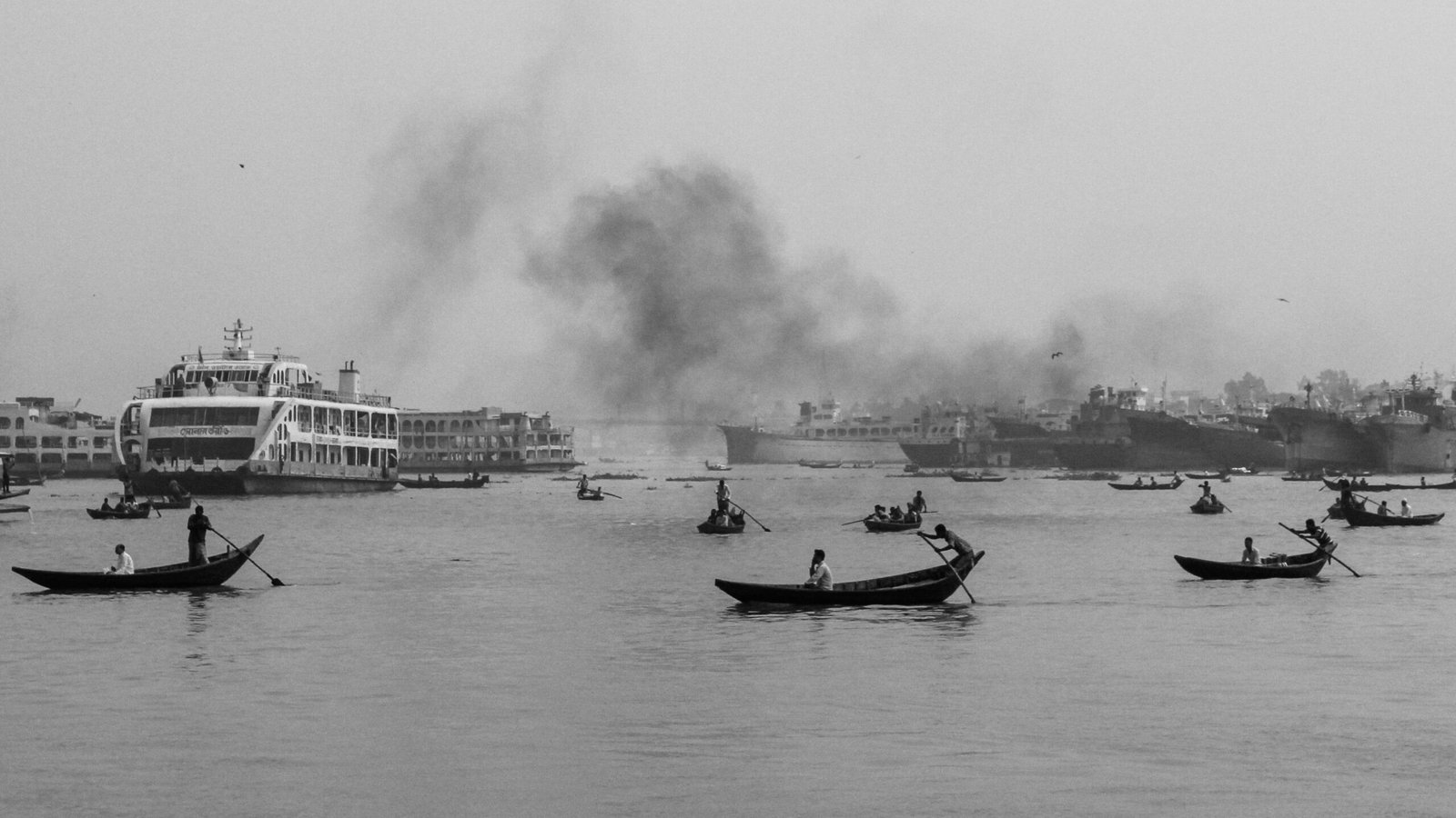 Grayscale image of boats and a ferry on Buriganga River, Dhaka, Bangladesh.